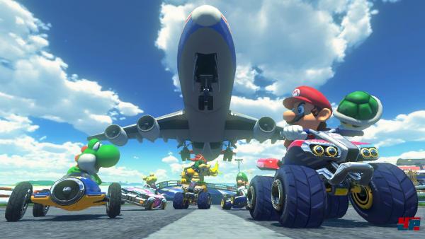 Mario macht sich bereit, Bowser einen Schildkrötenpanzer vor das Fahrzeug zu werfen.