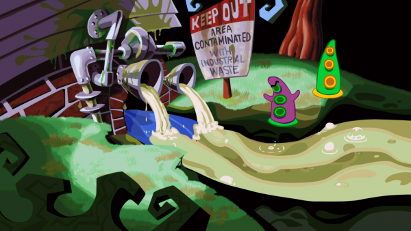 Screenshot: Ein purpur-farbenes Tentakel mit kleinen Stummelhänden steht neben einem grünen Tentakel ohne Hände an einem Abwasserrohr.  Neben den Beiden ist ein Schild mit der Aufschrift "Keep Out Area Contaminated with Industrial Waste"