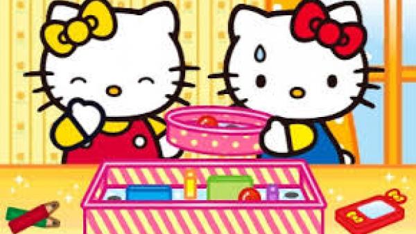 Zwei Hello Kitty Figuren vor einer Schachtel mit Malutensilien